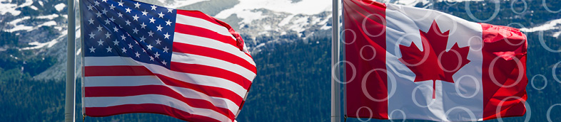 Drapeaux canadiens et américains dans les montagnes.