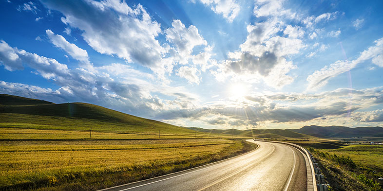 winding road with sunny sky