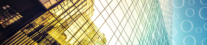 Immeuble de bureaux en verre montrant le reflet des bâtiments environnants.
