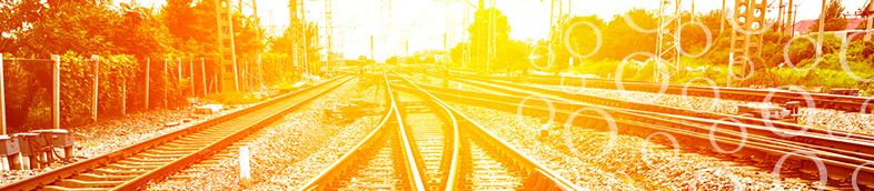 Merging railroad tracks with bright orange lighting.