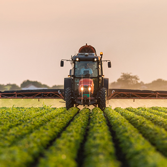 Pulvérisateur de pesticides par tracteur sur le champ de soja au printemps