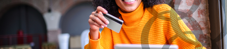 Woman using her credit card to pay the online purchase.
