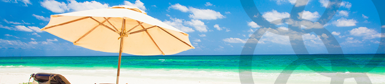 Deux transats et un parasol sur une plage de sable.