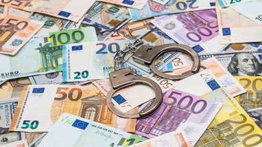 Handcuffs on top of bank notes