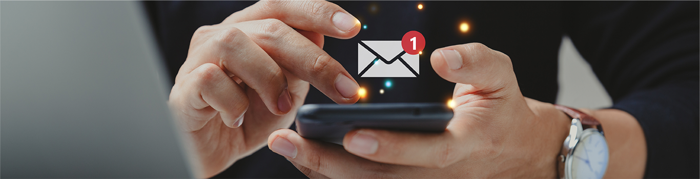 a person using a smartphone, there is a mail icon notification hovering above the phone