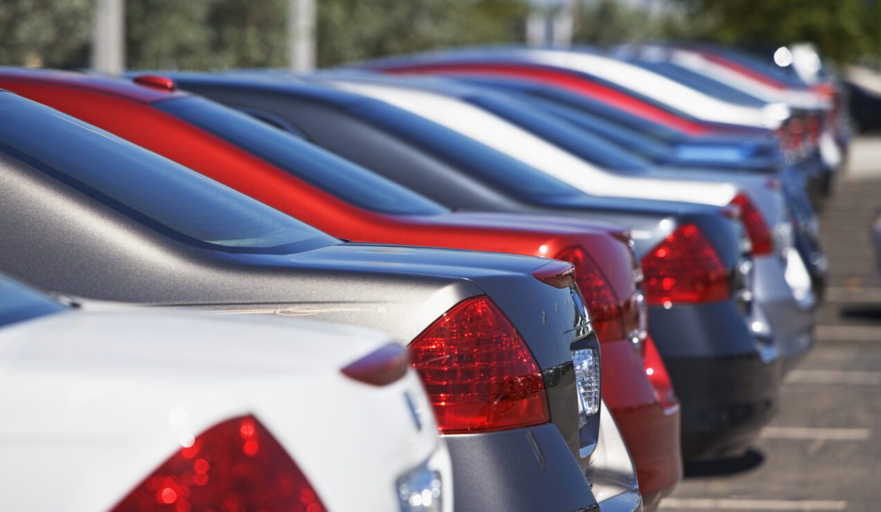 Cars parked in a parking lot with alternating colors of gray, blue, and red.