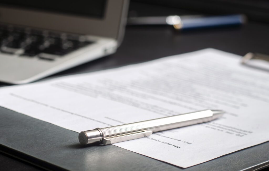 Pen and signature on paper.