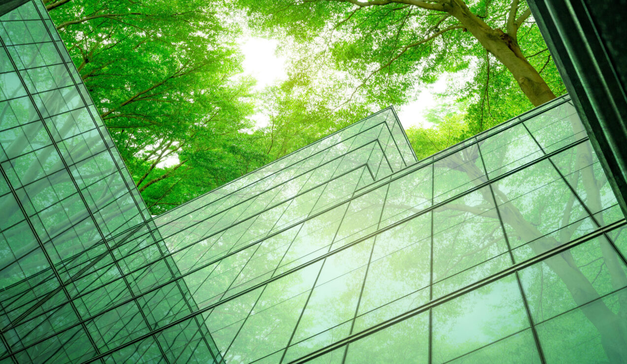 Eco-friendly building in the modern city. Sustainable glass office building with tree for reducing heat and carbon dioxide. Office building with green environment. Corporate building reduce CO2.
